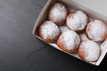 Delicious sweet buns in box on dark gray table, top view. Space for text