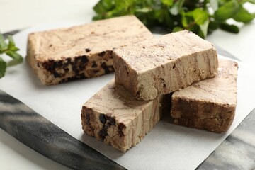 Pieces of tasty chocolate halva on table, closeup