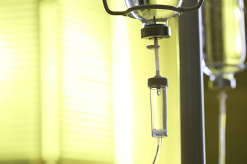 IV drip against blurred yellow background, space for text