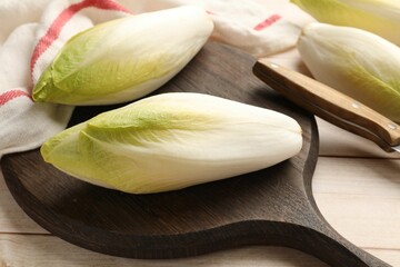 Raw ripe chicories on wooden table, closeup