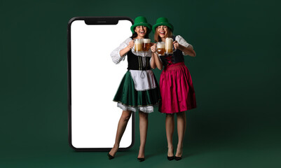 Irish waitresses with glasses of beer on green background. St. Patrick's Day celebration