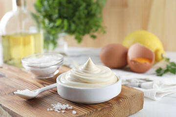 Fresh mayonnaise sauce in bowl and salt on table