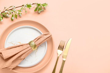 Beautiful table setting with blooming tree branch on nude background