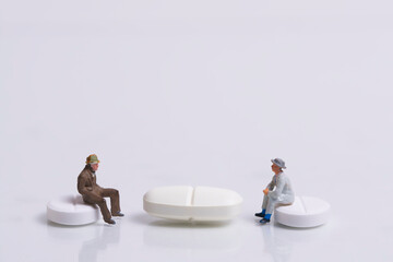 waiting patients sitting on medication in the form of tablets, white background, miniature figures scene