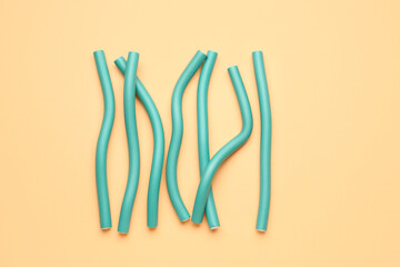 Hair curlers on yellow background