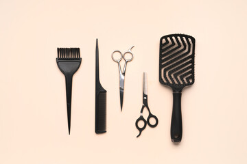 Hairdresser's brushes with scissors on beige background