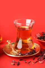 Glass of Turkish tea on red background