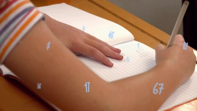 Animation of numbers over biracial schoolboy writing in notebook at school