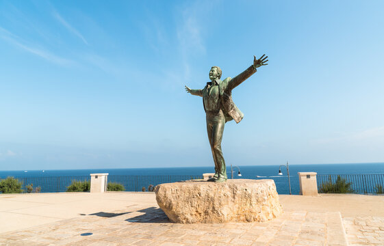 Polignano a Mare, Puglia, Italy - October 4, 2023: Bronze sculpture to Domenico Modugno, Italian musician and politician, on the seafront in Polignano a Mare.