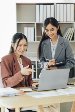 Group of young asian businesswoman working and brainstorming in workshop and analyzing marketing reports startup project infographics in the office.