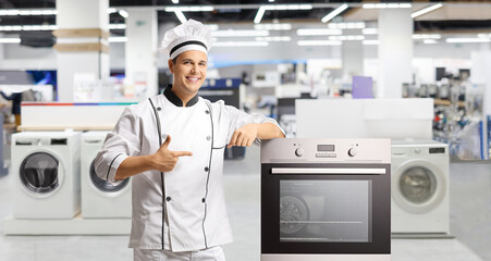 Male chef pointing at a stove in an appliance store