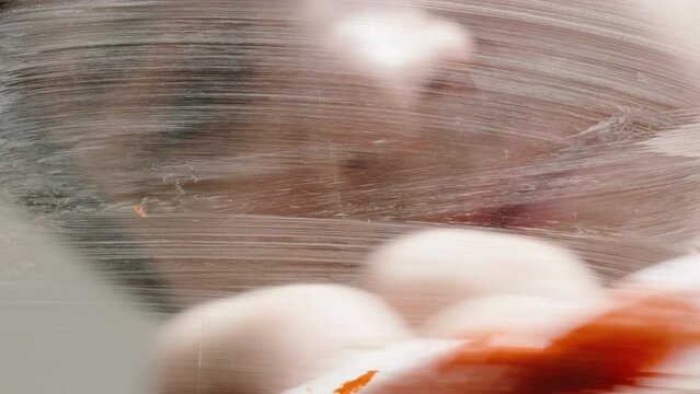 The heart drawn on the glass with red paint, the man spits on it and wipes it with a cloth. Close-up.