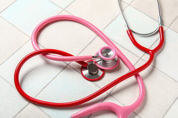 Modern stethoscopes on light  background