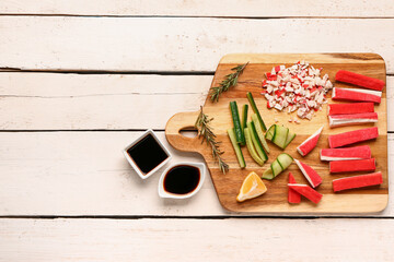Board with tasty crab sticks and sauces on light wooden background © Pixel-Shot