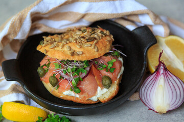 Gourmet Smoked Salmon Bagel With Fresh Herbs and Capers on a Stylish Ceramic Plate