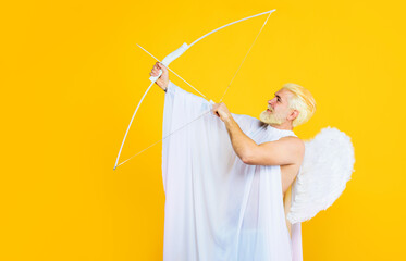 Valentines Day celebration. Cupid man in white angel wings with bow and arrow. God of love....