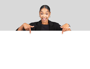 Professional African American woman in a business suit happily pointing downwards to a blank...