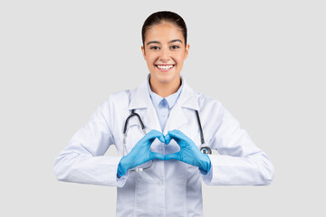 Smiling millennial caucasian doctor, nurse cardiologist in white coat, protective gloves