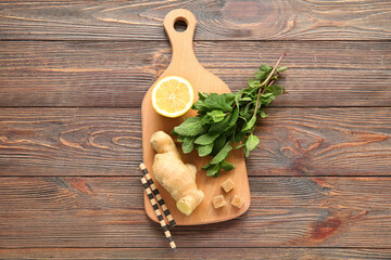 Board with lemon, mint and ginger on brown wooden background