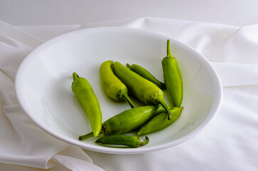 Close-up of a bowl of freshly picked green hot peppers