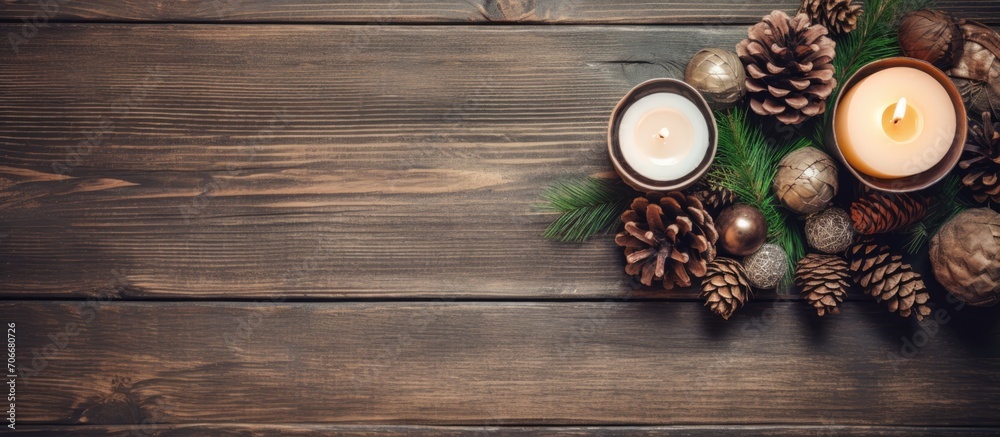 Canvas Prints Winter holiday preparations with cozy hands creating a rustic Christmas wreath using fir branches, pine cones, candle, twine, bells on a wooden table, seen from a top view.