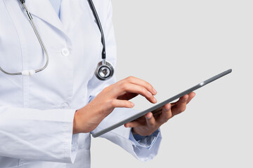 Millennial caucasian lady professional doctor use tablet, chatting on light background