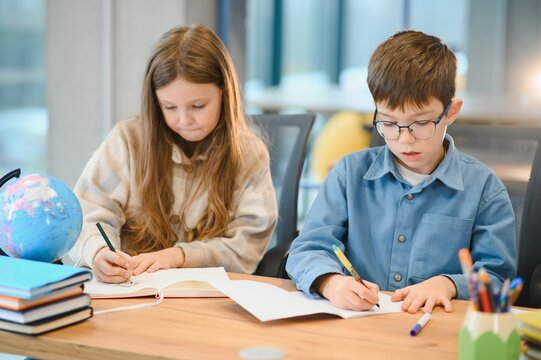 students to schoolwork during lesson in light classroom at school