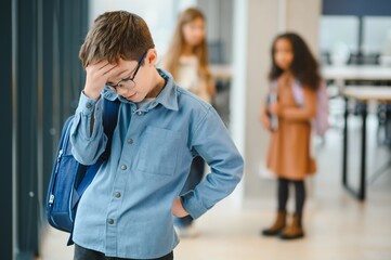 upset boy at school covering his face with his hands. Bullying at school