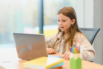 Smiling little Caucasian girl have video call distant class with teacher