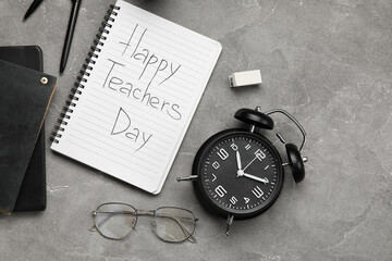 Notebooks with text HAPPY TEACHERS DAY, eyeglasses and alarm clock on grunge grey background