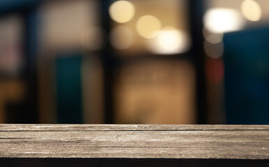 Empty dark wooden table in front of restaurant abstract blurred bokeh background. can be used to demonstrate or mount your products. Layout for space