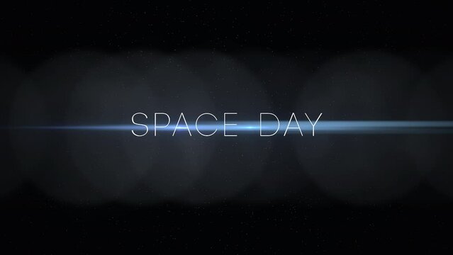 A captivating image with a black background and a vivid blue light shining from the center. Space Day is written in white letters on the left side