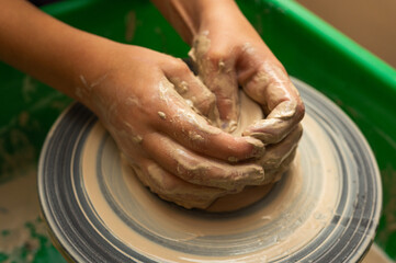 Clay, ceramics or hands in a design workshop working on an artistic cup or mug. The hand of a creative artist or worker making crafts in sculpture