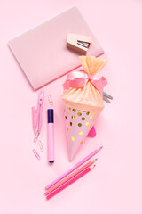 School cone with different stationery on pink background