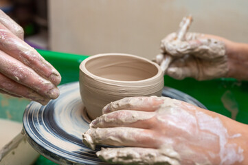 Clay, ceramics or hands in a design workshop working on an artistic cup or mug. The hand of a creative artist or worker making crafts in sculpture