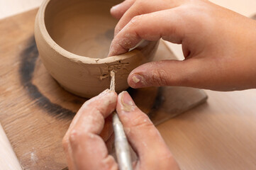 Clay, pottery or hands in designer workshop working on an artistic cup or mug mold in small...