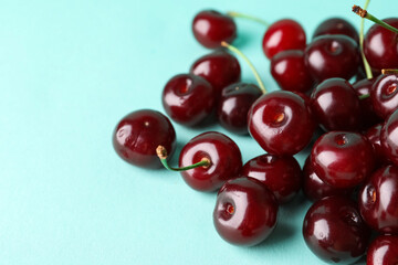 Heap of sweet cherries on blue background