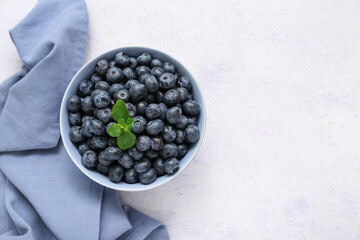 Bowl with fresh blueberry on light background