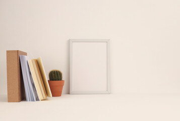 Office table (shelf) with empty frame and decorative objects. Copy space creative ligt beige workspace.