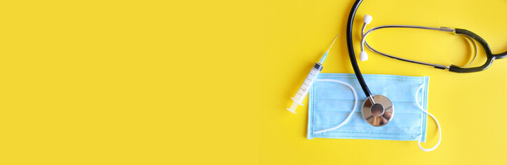 Stethoscope and medical mask on a yellow background copy space for web. Medical internet banner