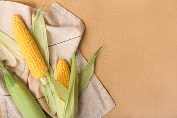 Fresh corn cobs on brown background