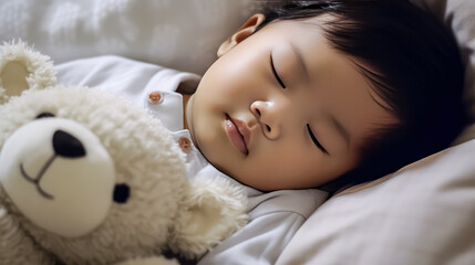 Obraz na płótnie Canvas portrait of a charming sleeping baby with a cute teddy bear on a comfortable bed.