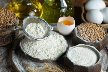 Kneading dough with flour and eggs, on an old background