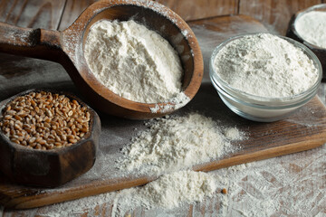 Kneading dough with flour and eggs, with kitchen accessories, on table and old background.