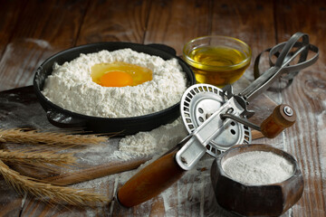 The process of kneading dough in the kitchen. Eggs, flour and other ingredients on the kitchen table in a composition.