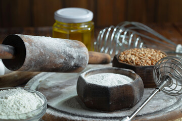 Kneading dough with flour and eggs, on an old background