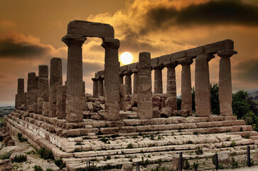 Agrigento (Italy, Sicily) the Valley of the Temples, a suggestive dawn illuminates the ruins of the Temple of Hera Lacinia (Juno) - obrazy, fototapety, plakaty