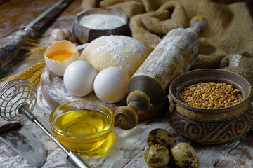 The process of kneading dough in the kitchen. Eggs, flour and other ingredients on the kitchen table in a composition.
