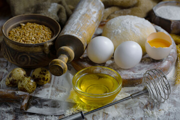 The process of kneading dough in the kitchen. Eggs, flour and other ingredients on the kitchen table in a composition.