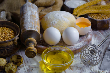 Kneading dough with flour and eggs, on an old background